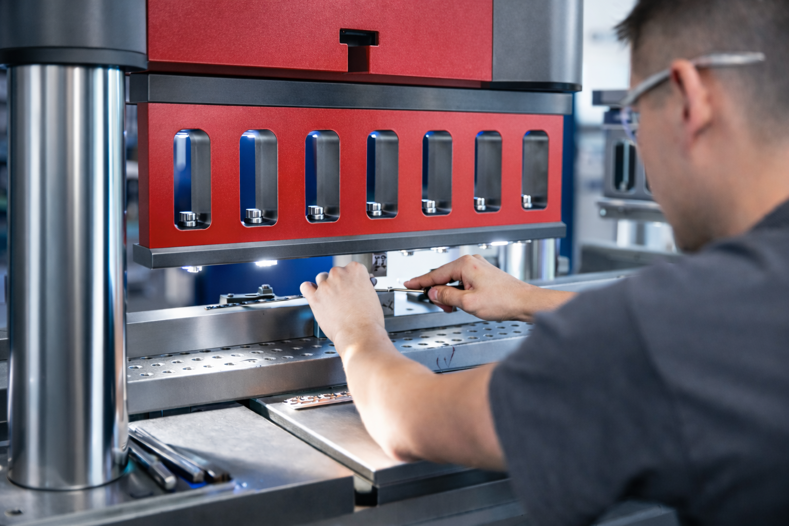Hohe Fertigungstiefe im Prototypenbau bei all-forming: Facharbeiter richtet eine moderne Werkzeugpresse f&uuml;r die exakte Blechbearbeitung ein.